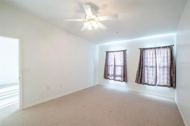 a living room with furniture and a dining table next to a window