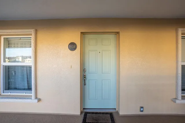 an empty room with a chandelier fan and windows