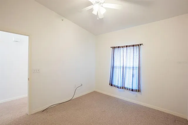 an empty room with windows and fan