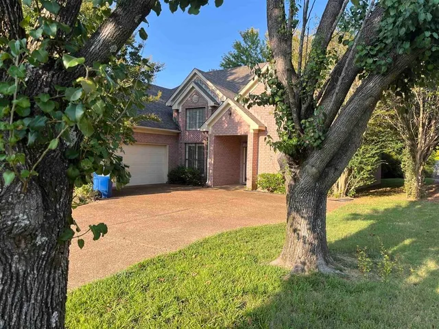 a view of a house with a tree in a yard