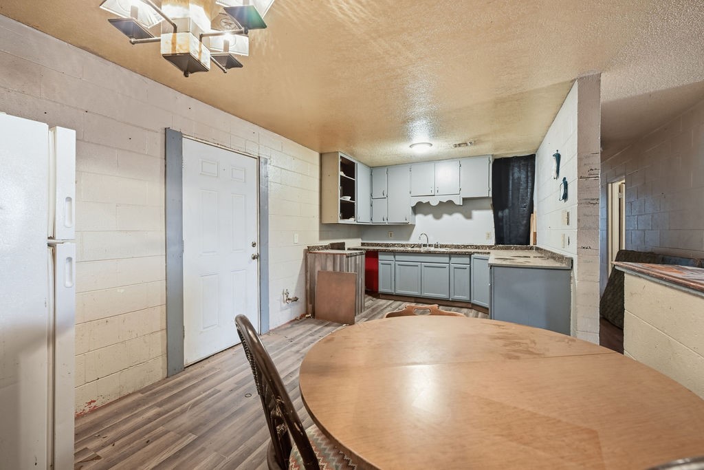 508 South Kenneth Avenue Monahans, TX 79756 - Photo 6 of 39 a kitchen with refrigerator cabinets and wooden floor