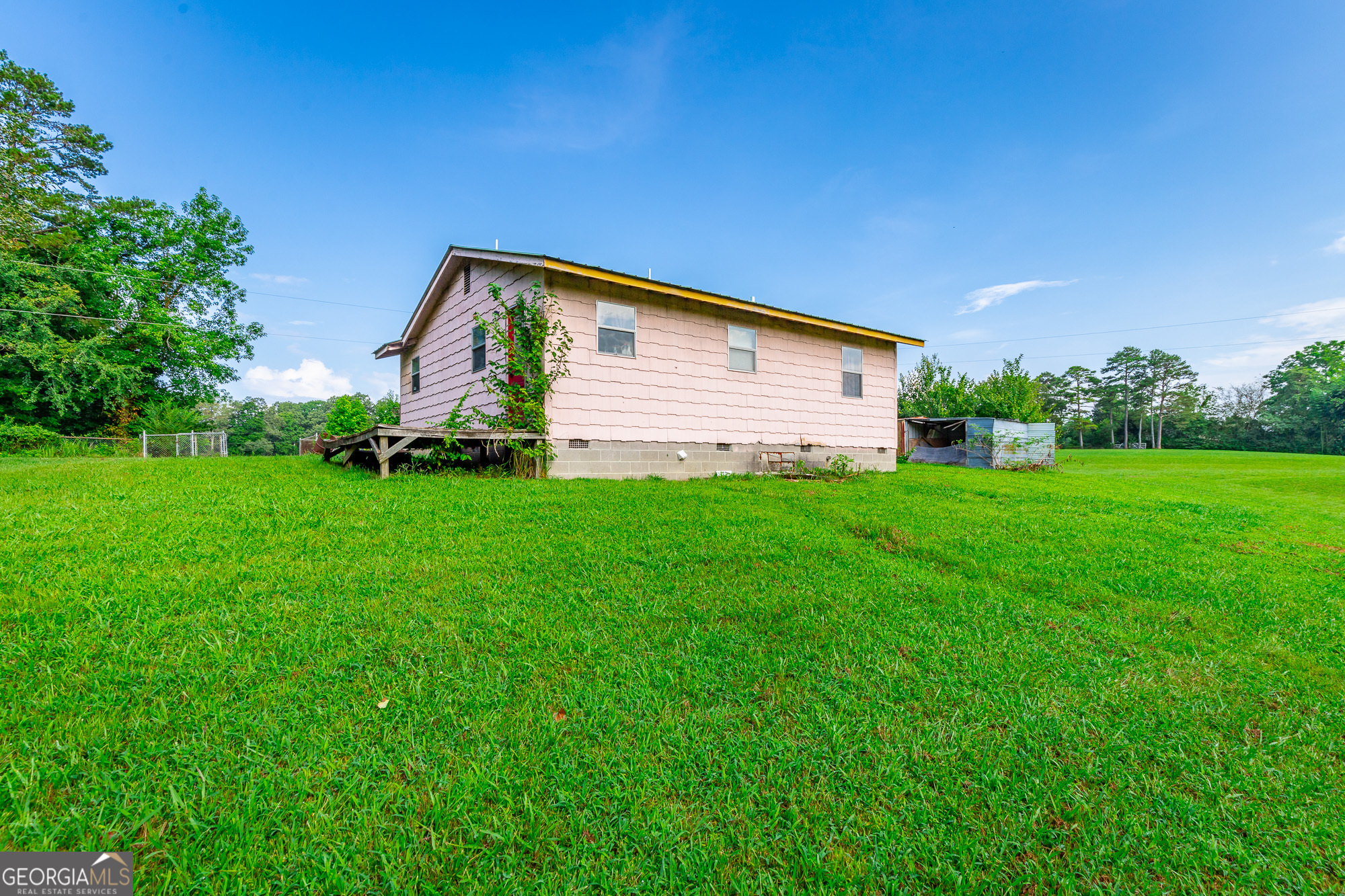 77 Bolton Road Trenton, GA 30752 - Photo 22 of 47 a backyard of a house with potted plants and large tree