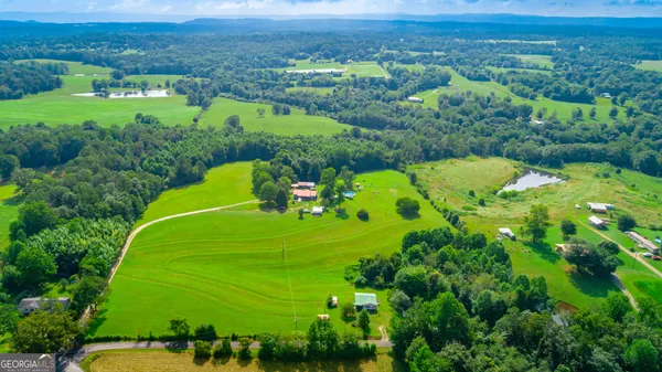an aerial view of a houses with a lush green forest