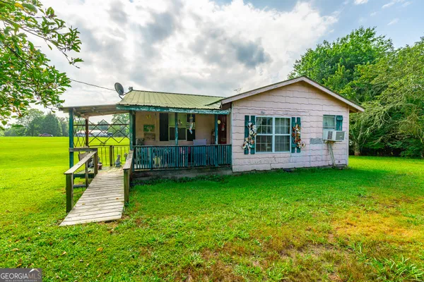 a view of a house with a backyard and a patio