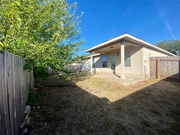 a view of a house with backyard and trees