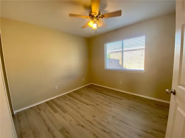 an empty room with a window and a fan