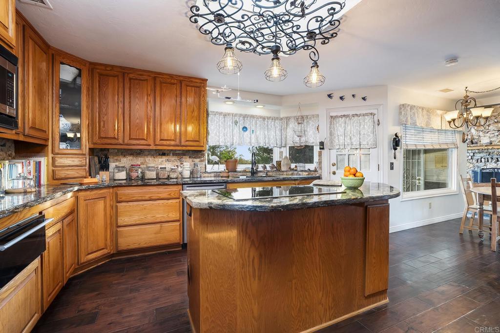 23002 Japatul Valley Road Alpine, CA 91901 - Photo 12 of 65 a kitchen with kitchen island granite countertop lots of counter top space and stainless steel appliances