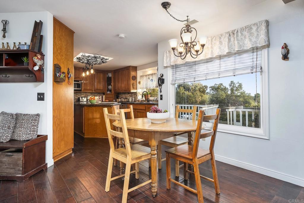 23002 Japatul Valley Road Alpine, CA 91901 - Photo 16 of 65 a view of a dining room with furniture a chandelier and wooden floor