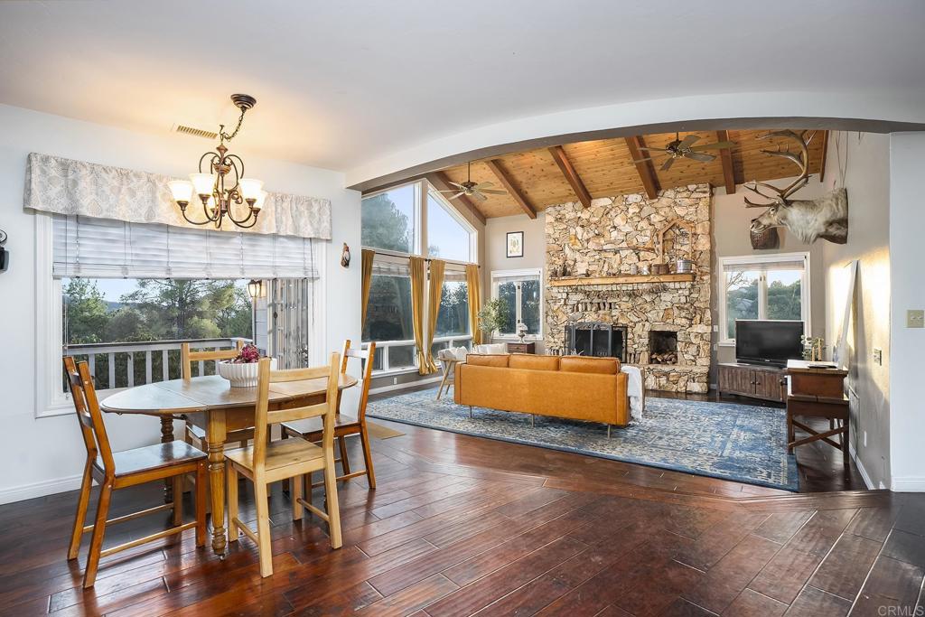 23002 Japatul Valley Road Alpine, CA 91901 - Photo 17 of 65 a dining room with wooden floor a chandelier a glass table and chairs