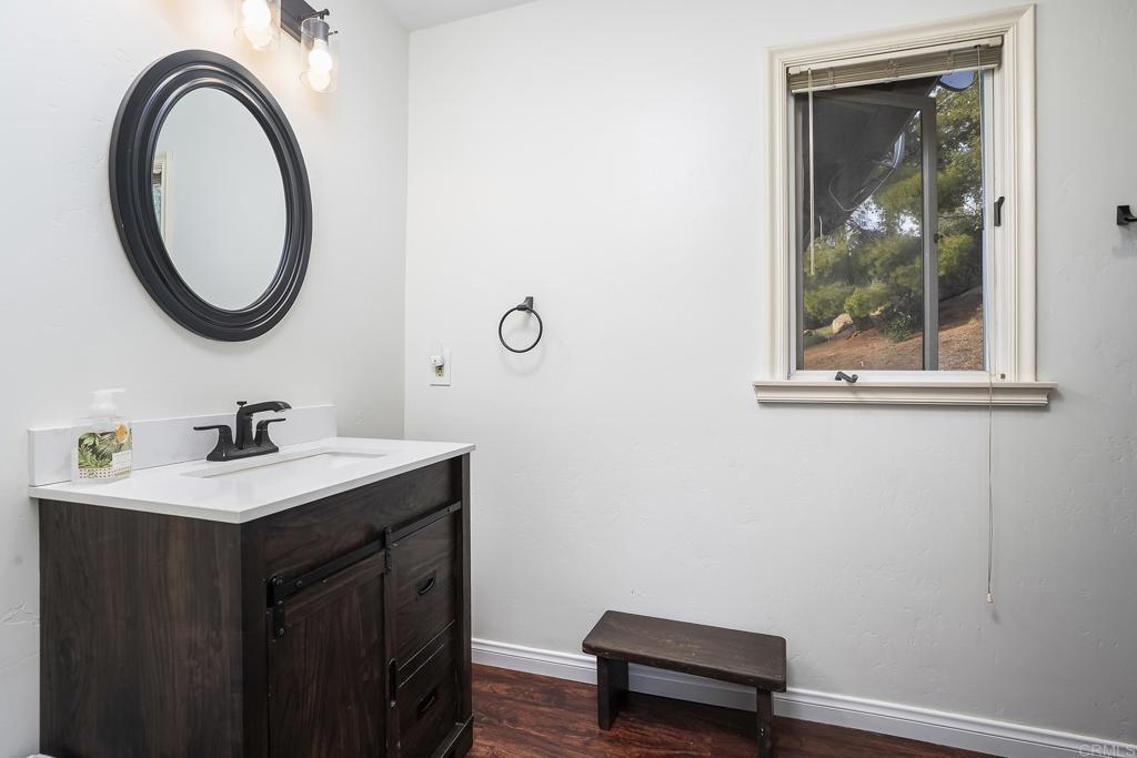 23002 Japatul Valley Road Alpine, CA 91901 - Photo 26 of 65 a bathroom with a sink a toilet and a mirror