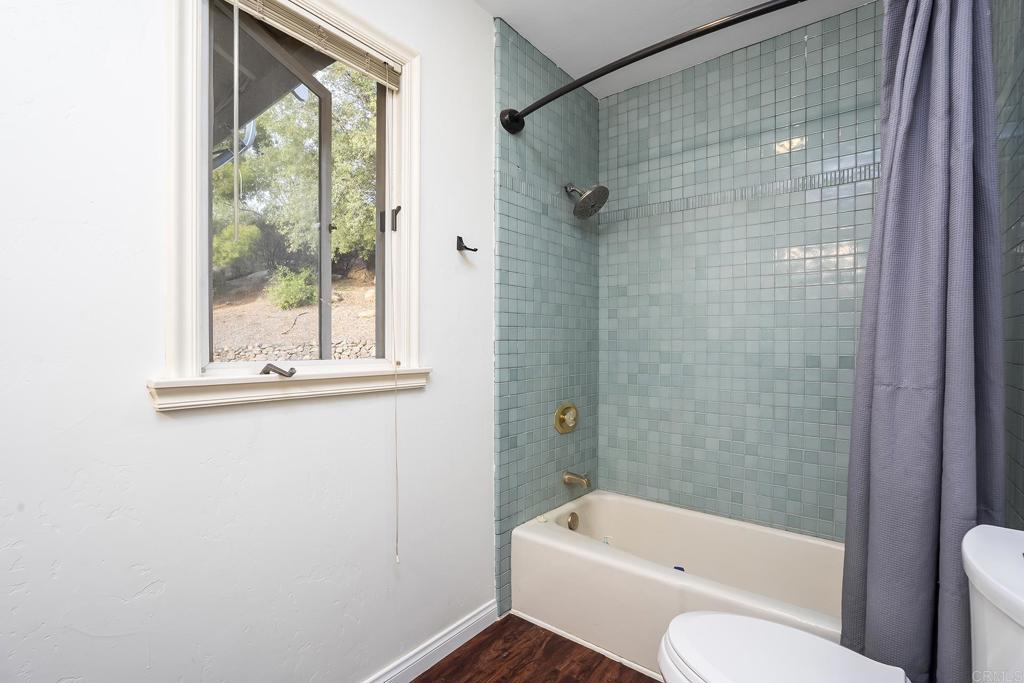 23002 Japatul Valley Road Alpine, CA 91901 - Photo 27 of 65 a bathroom with a toilet and a bathtub