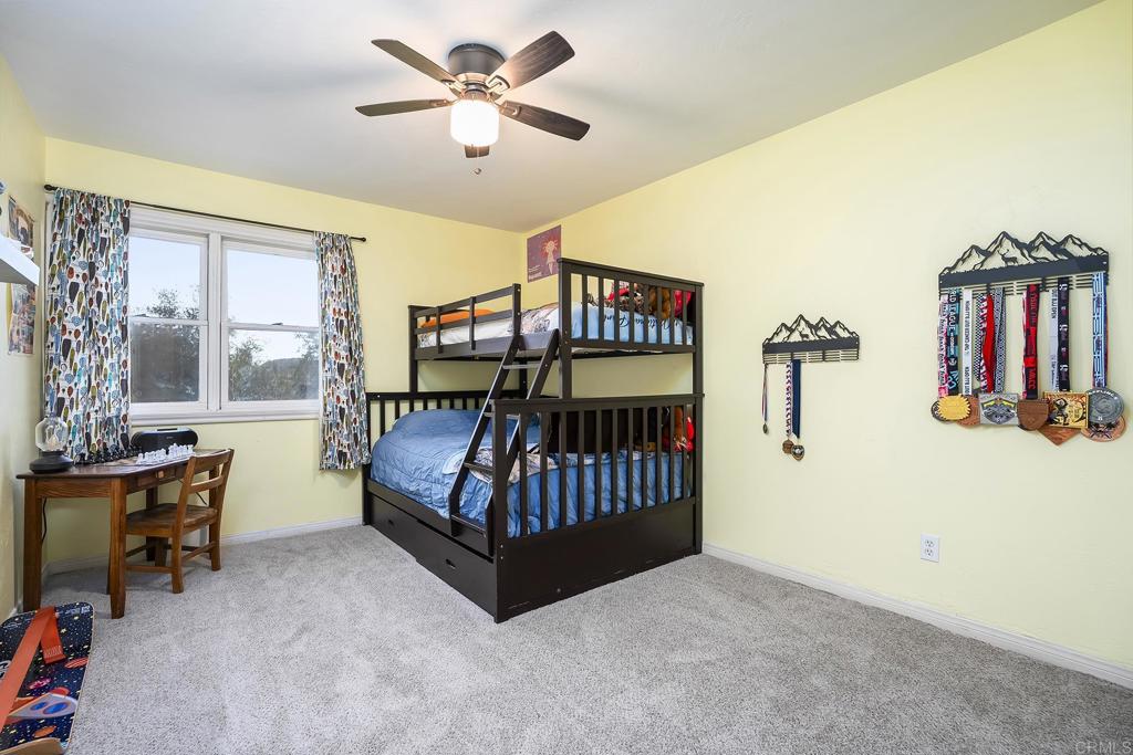 23002 Japatul Valley Road Alpine, CA 91901 - Photo 28 of 65 a bedroom with a bed and wooden floor