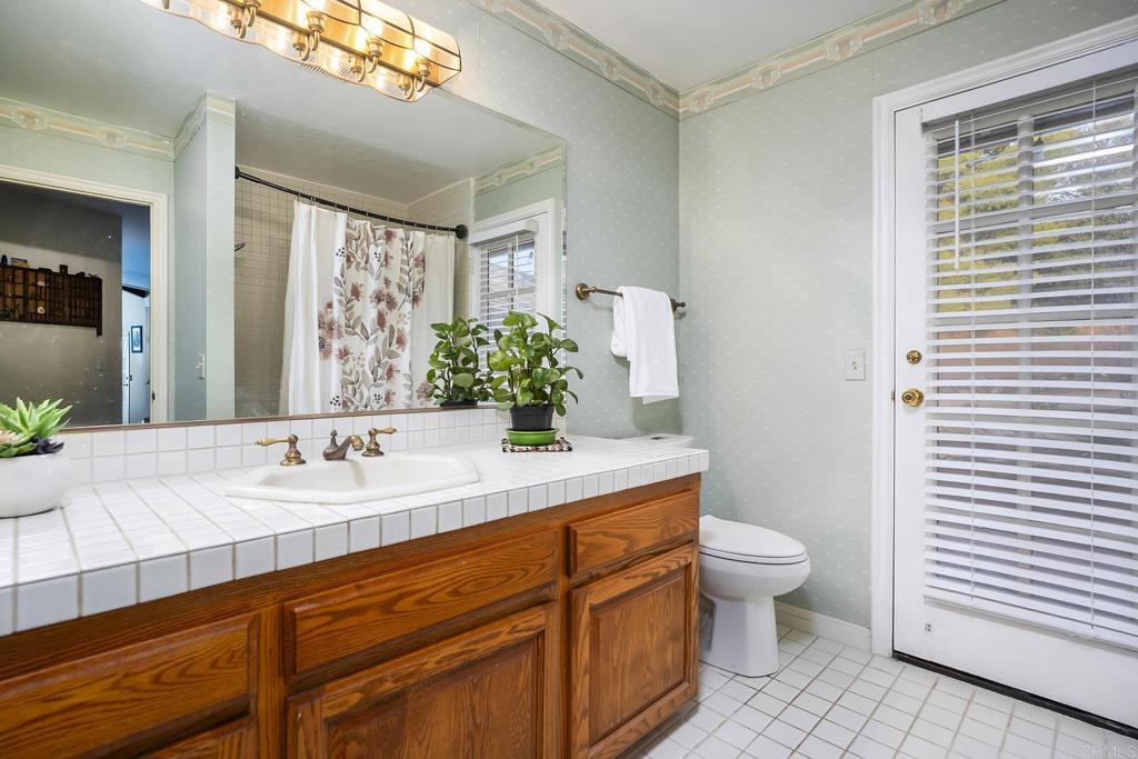 23002 Japatul Valley Road Alpine, CA 91901 - Photo 30 of 65 a bathroom with a granite countertop sink mirror vanity and toilet
