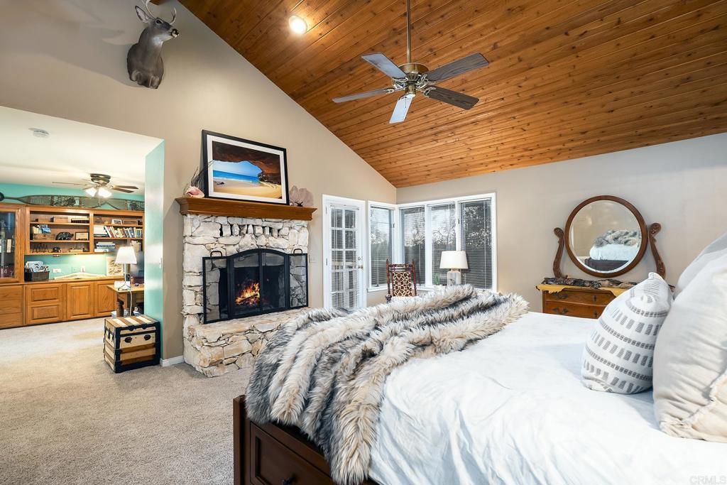 23002 Japatul Valley Road Alpine, CA 91901 - Photo 31 of 65 a large bedroom with bed and a fireplace