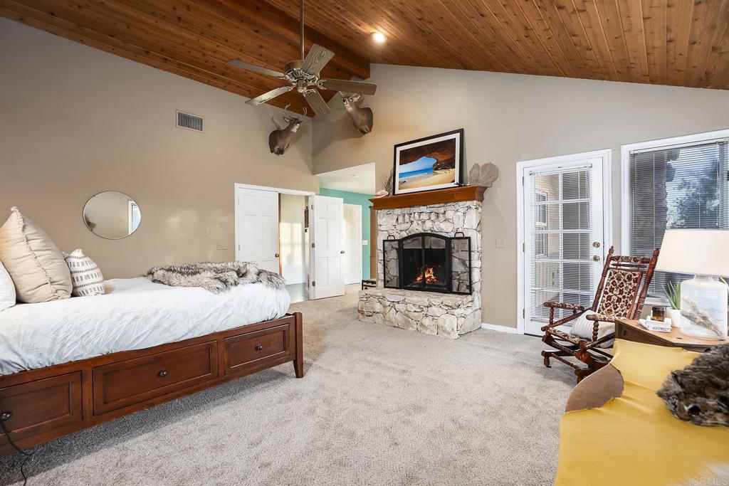 23002 Japatul Valley Road Alpine, CA 91901 - Photo 33 of 65 a spacious bedroom with a bed and a fireplace