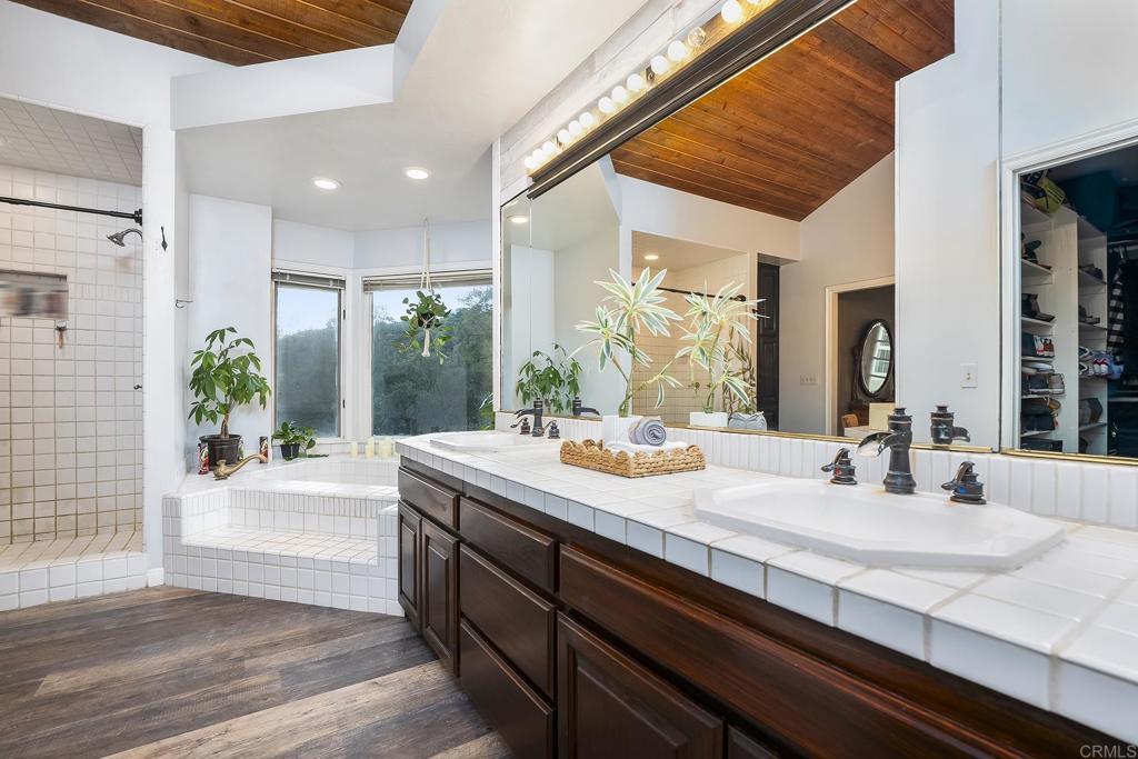 23002 Japatul Valley Road Alpine, CA 91901 - Photo 34 of 65 a bathroom with a granite countertop sink a large mirror and shower