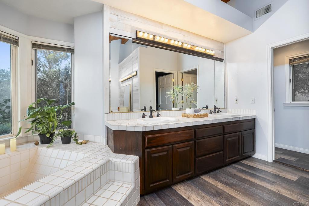 23002 Japatul Valley Road Alpine, CA 91901 - Photo 36 of 65 a spacious bathroom with a double vanity sink and a mirror