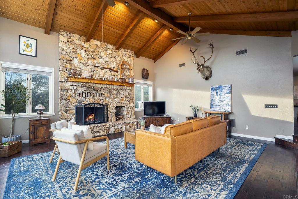 23002 Japatul Valley Road Alpine, CA 91901 - Photo 7 of 65 a living room with furniture a fireplace and a table