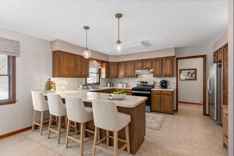 176 Wexford Road Valparaiso, IN 46385 - Photo 16 of 54 a kitchen with stainless steel appliances granite countertop a sink a stove a refrigerator cabinets and a dining table