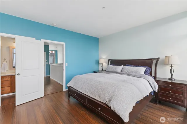 a large bed sitting in a bedroom next to a window and a wooden floor