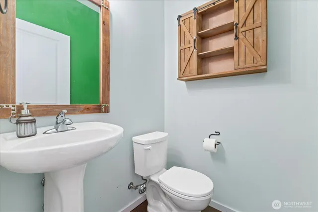 a bathroom with a toilet sink and mirror