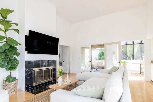 a living room with furniture a flat screen tv and a fireplace