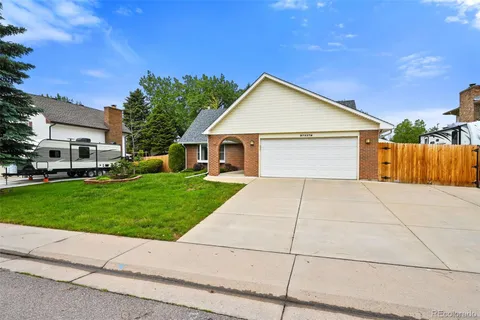 a view of a house with a yard and large tree