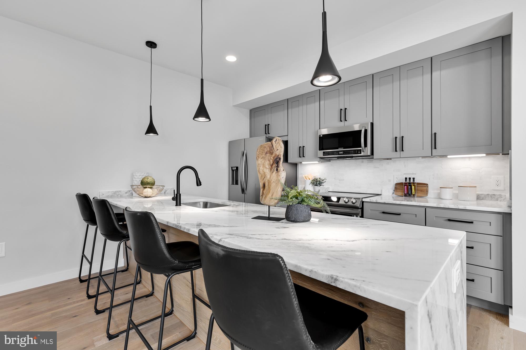 537 Park Road Northwest, Unit TH2 Washington, DC 20010 - Photo 16 of 60 a kitchen with granite countertop a table chairs a sink and dishwasher