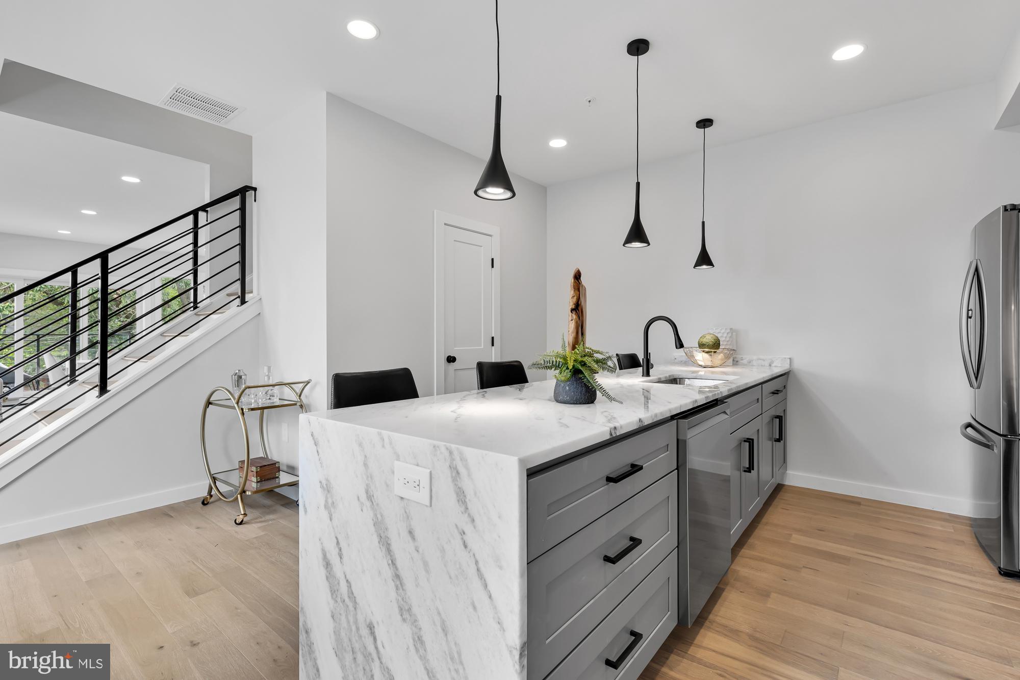 537 Park Road Northwest, Unit TH2 Washington, DC 20010 - Photo 19 of 60 a kitchen with kitchen island a sink stove and wooden floor