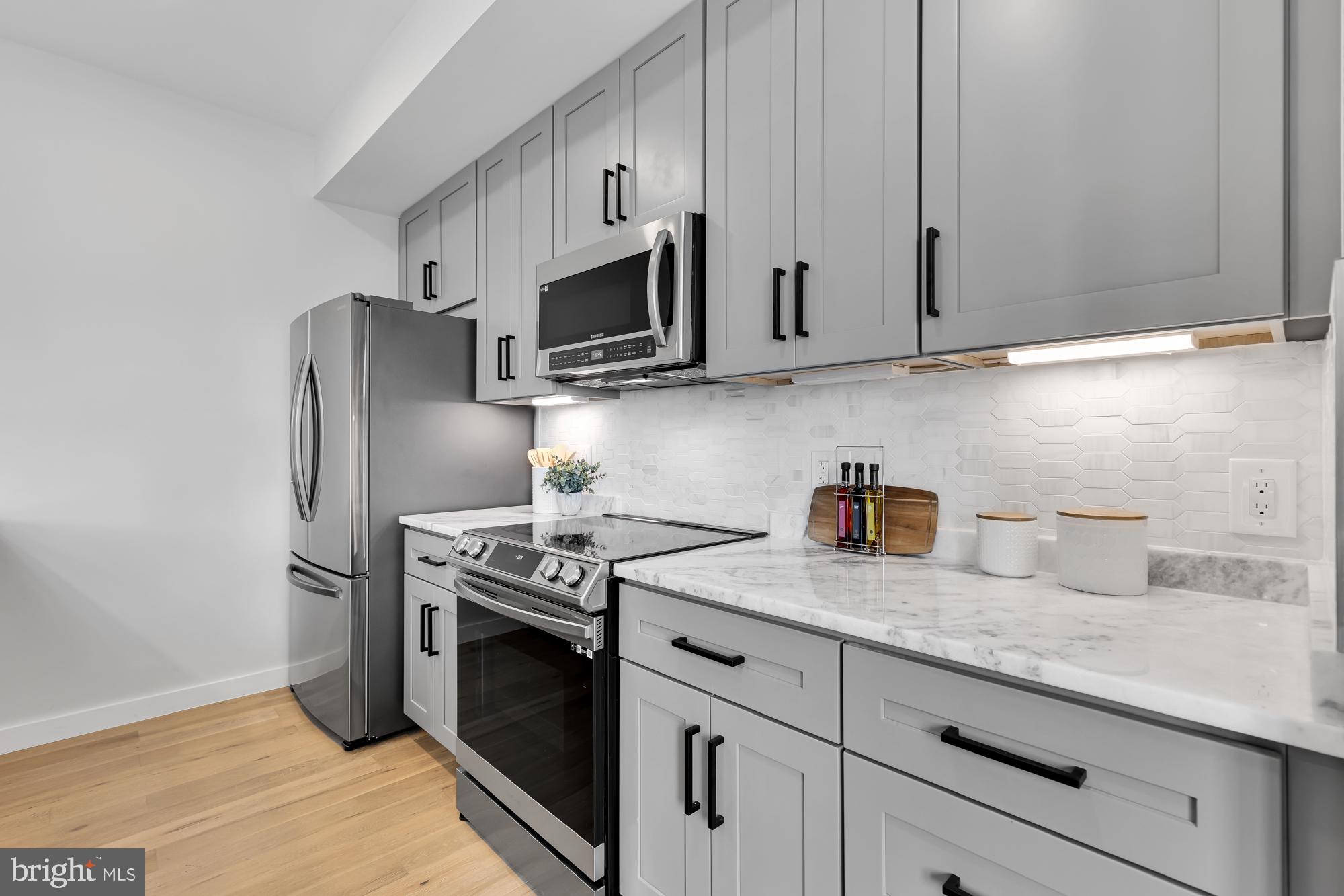 537 Park Road Northwest, Unit TH2 Washington, DC 20010 - Photo 20 of 60 a kitchen with granite countertop white cabinets stainless steel appliances and sink