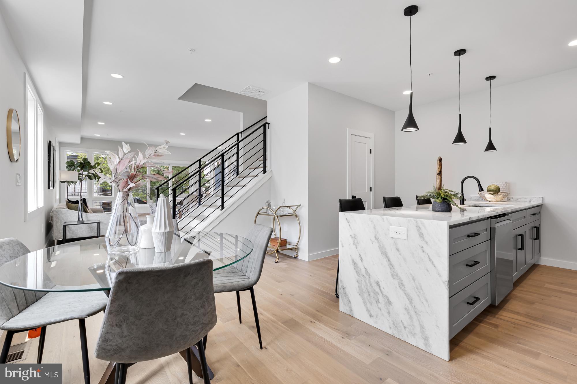537 Park Road Northwest, Unit TH2 Washington, DC 20010 - Photo 21 of 60 a kitchen with stainless steel appliances kitchen island granite countertop a table chairs and a refrigerator