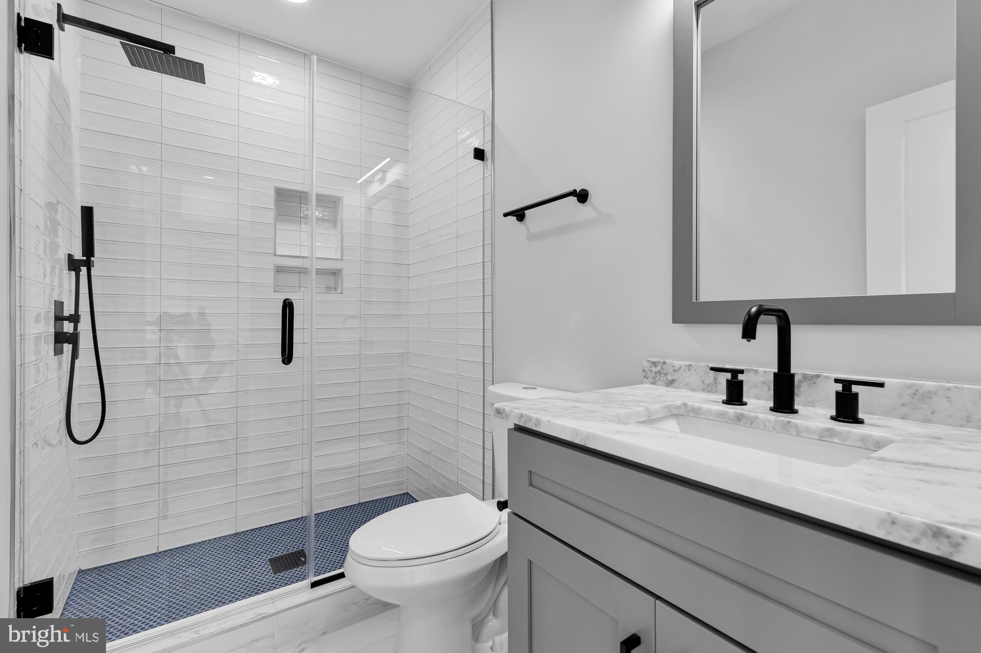 537 Park Road Northwest, Unit TH2 Washington, DC 20010 - Photo 32 of 60 a bathroom with a granite countertop sink a toilet and shower