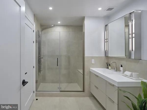 a bathroom with a shower sink and mirror