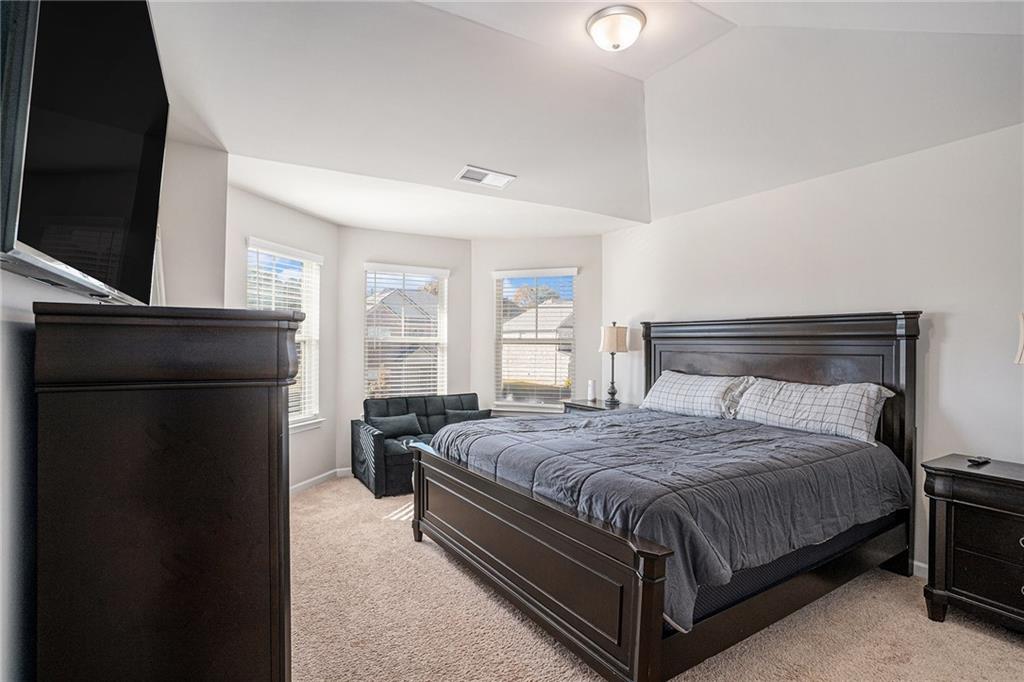 453 Sawmill Trace Hampton, GA 30228 - Photo 23 of 34 a bedroom with a bed and a flat tv screen on dresser