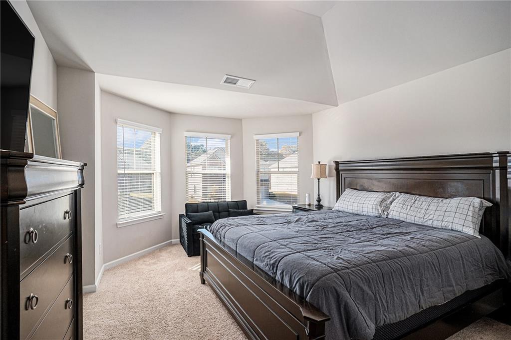453 Sawmill Trace Hampton, GA 30228 - Photo 24 of 34 a bedroom with a bed a fireplace and a flat tv screen on dresser