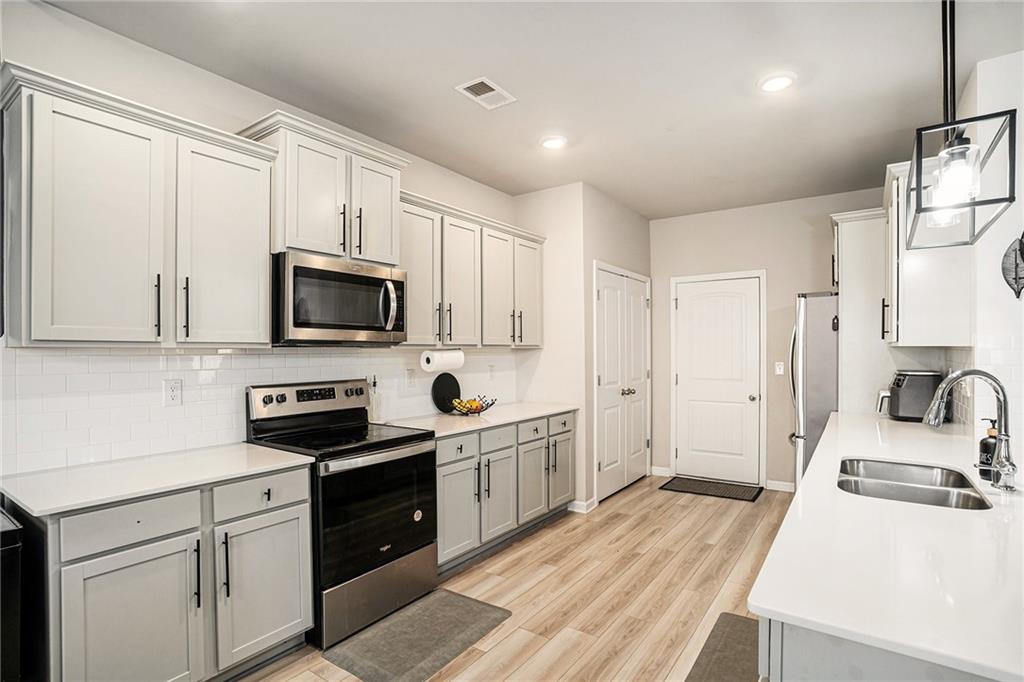 453 Sawmill Trace Hampton, GA 30228 - Photo 9 of 34 a kitchen with granite countertop a sink a stove and refrigerator