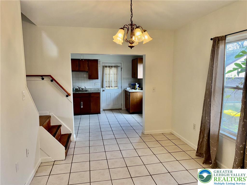 2955 Middletown Road Bethlehem, PA 18020 - Photo 7 of 20 A classic chandelier illuminates the tiled floors, extending into an adjacent kitchen space.