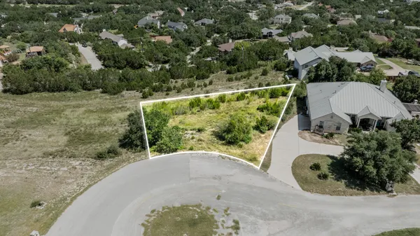an aerial view of a house with a yard and lake