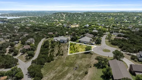 an aerial view of residential houses with outdoor space and trees