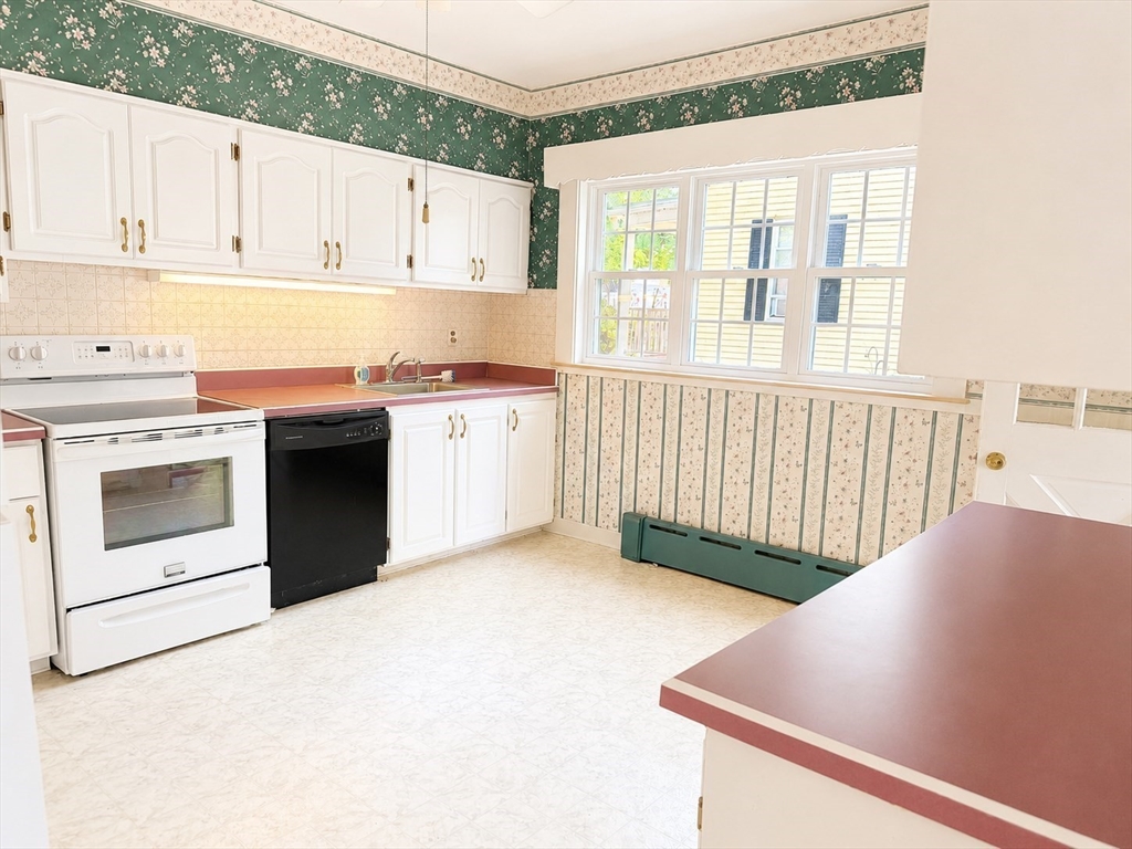 36 Plummer Avenue Lowell, MA 01852 - Photo 6 of 23 a kitchen with stainless steel appliances granite countertop a stove a sink and white cabinets