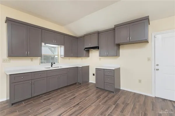 a kitchen with sink cabinets and wooden floor