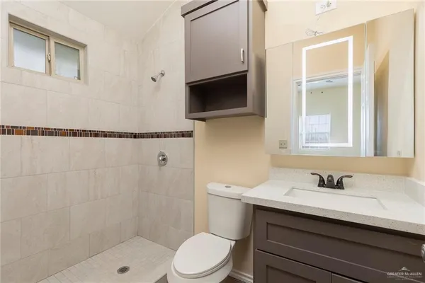 a bathroom with a sink a toilet and shower