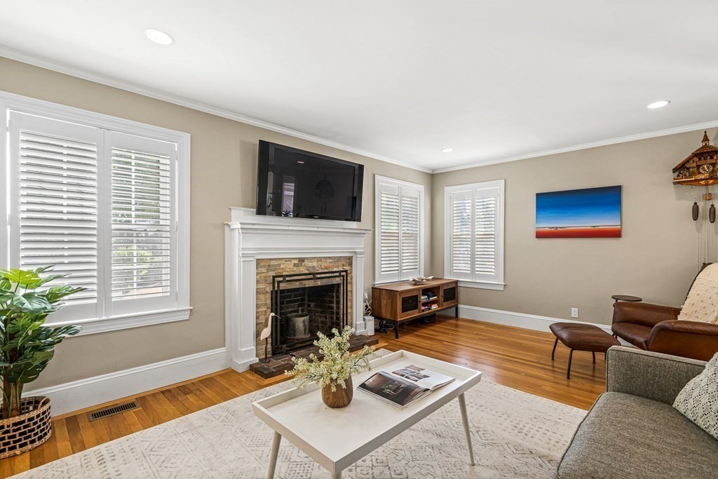 7 Perkins Avenue Reading, MA 01867 - Photo 20 of 42 a living room with furniture a flat screen tv and a fireplace