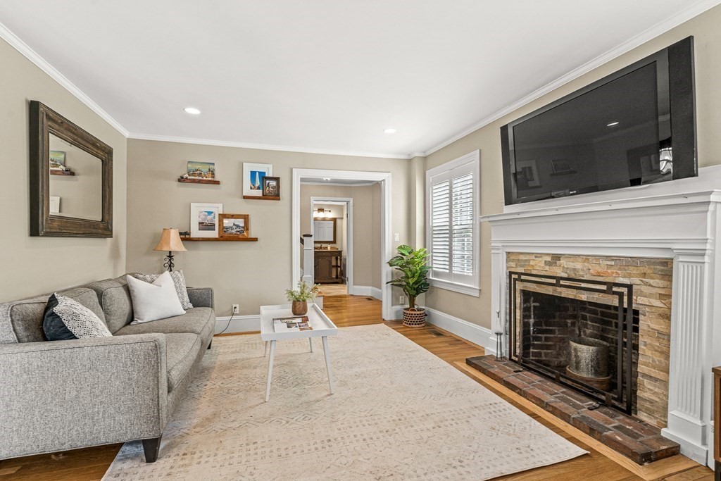7 Perkins Avenue Reading, MA 01867 - Photo 22 of 42 a living room with furniture a flat screen tv and a fireplace