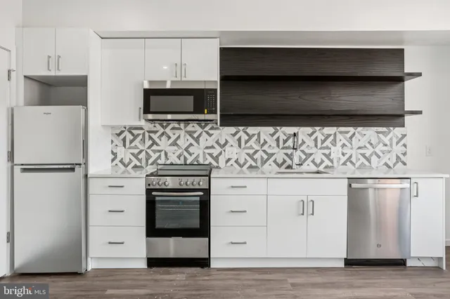 a kitchen with white cabinets and stainless steel appliances