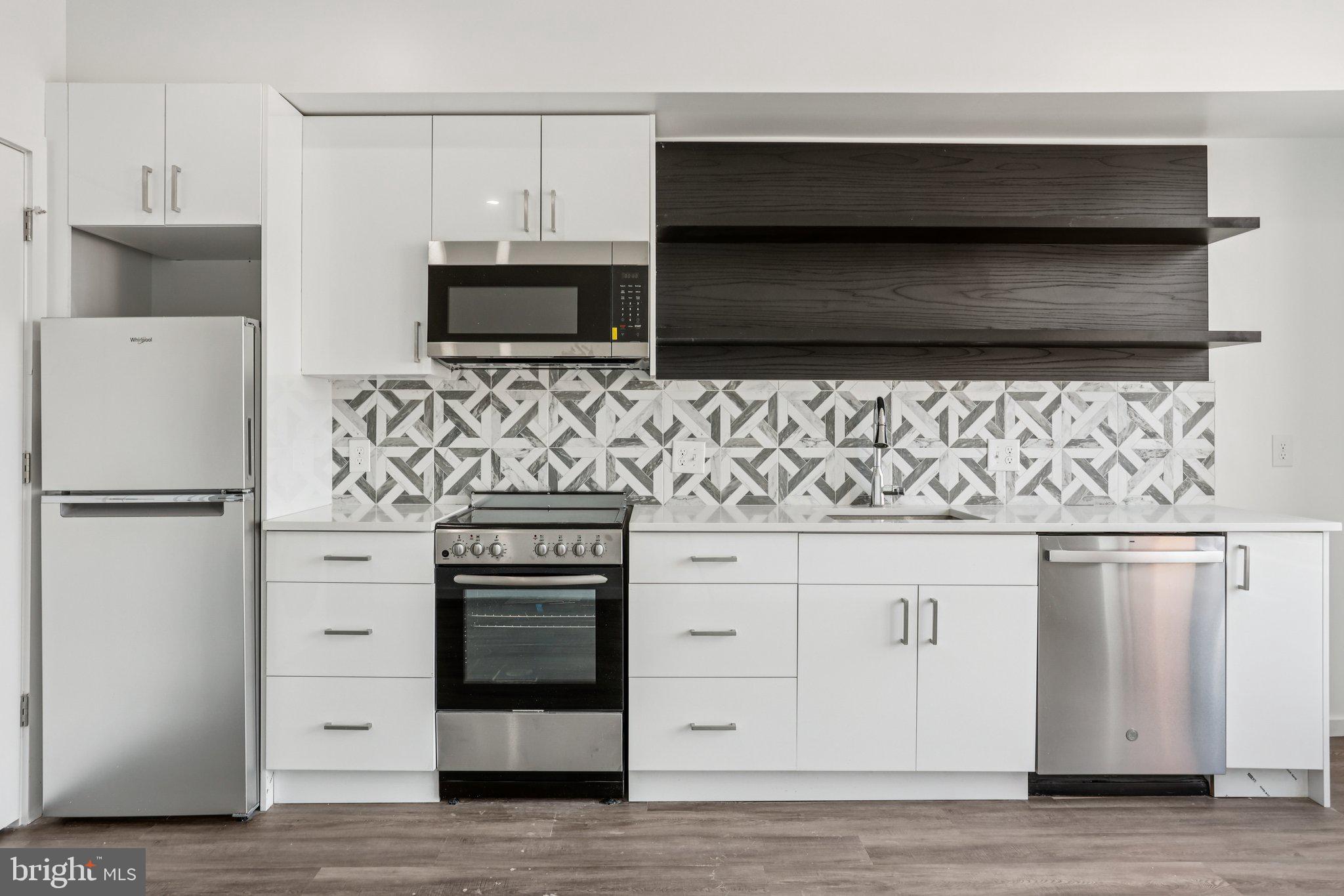 1201 Vine Street, Unit STUDIO Philadelphia, PA 19107 - Photo 1 of 29 a kitchen with white cabinets and stainless steel appliances