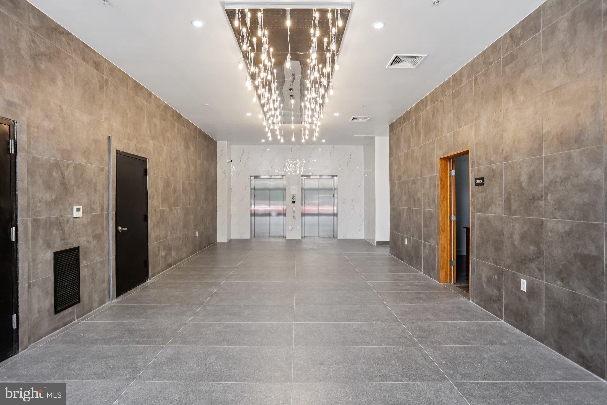 1201 Vine Street, Unit STUDIO Philadelphia, PA 19107 - Photo 19 of 29 a view of a hallway with chandelier