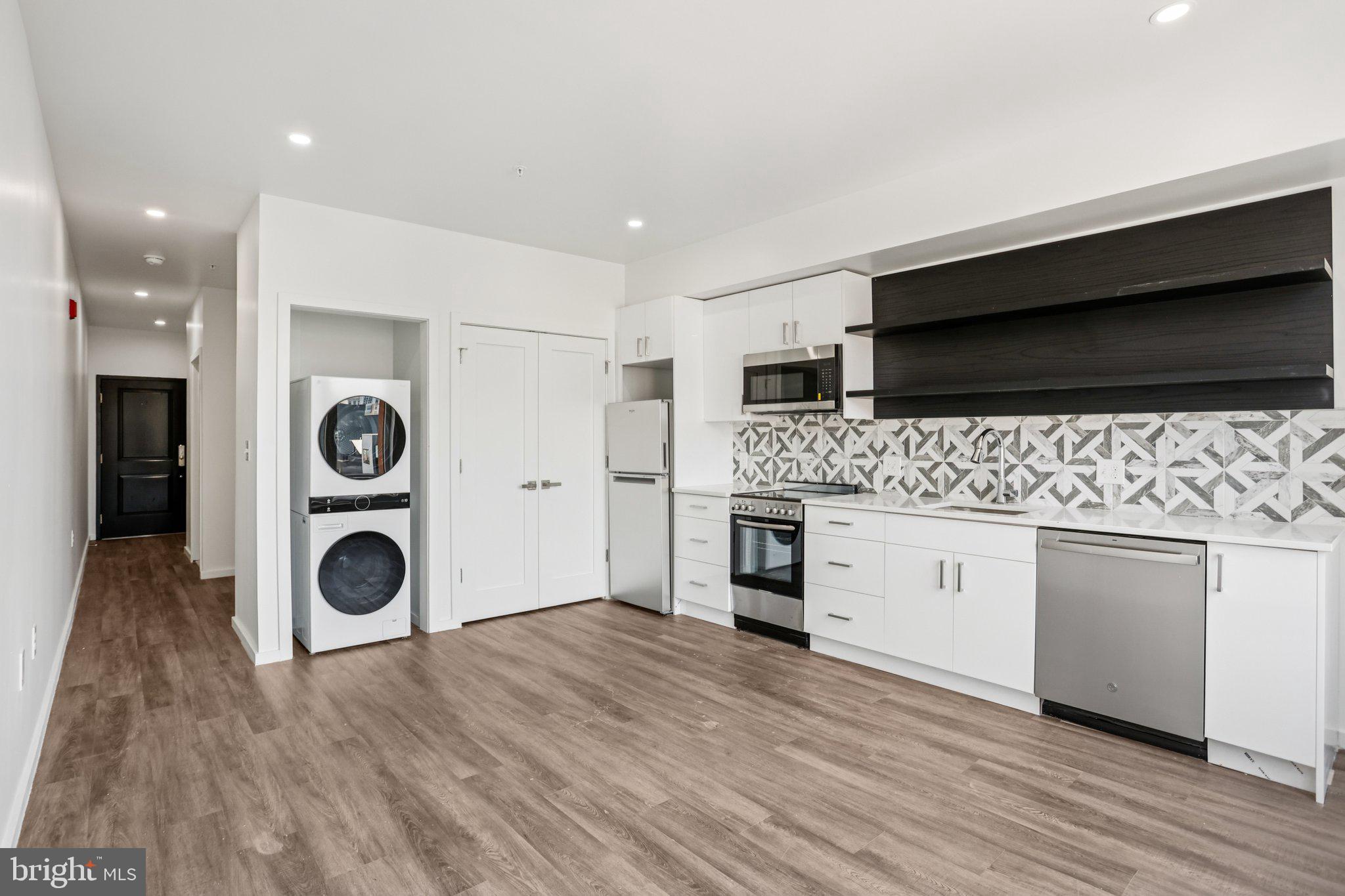 1201 Vine Street, Unit STUDIO Philadelphia, PA 19107 - Photo 2 of 29 a hall with stainless steel appliances granite countertop a stove and a wooden floors