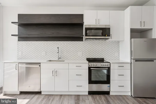 a kitchen with stainless steel appliances a stove a microwave and cabinets
