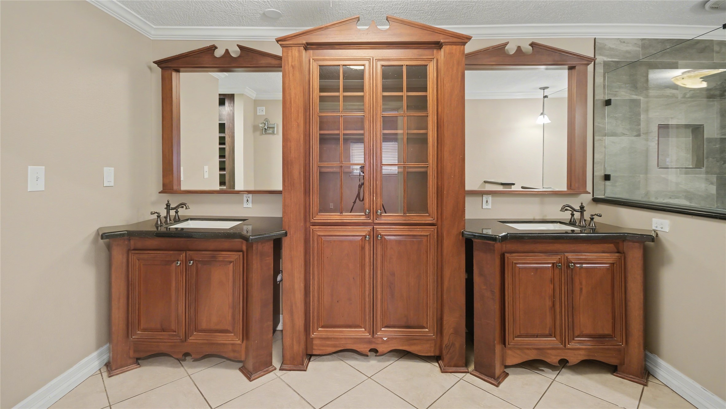 1431 Walnut Lane Houston, TX 77339 - Photo 15 of 46 This primary ensuite bathroom exudes elegance with its rich wooden cabinetry, dual sinks, and a luxurious glass-enclosed shower, creating a perfect blend of style and functionality.